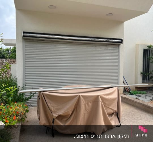 תריס מתכת סגור על קיר חיצוני של מבנה